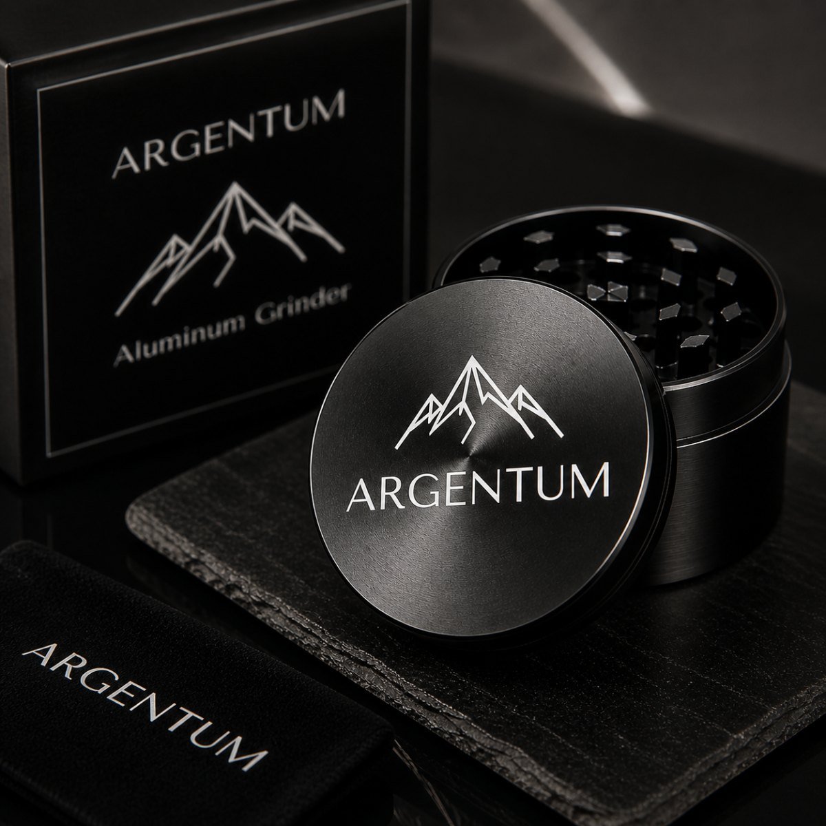 ARGENTUM four-piece black anodized aluminum spice grinder standing next to its black gift box